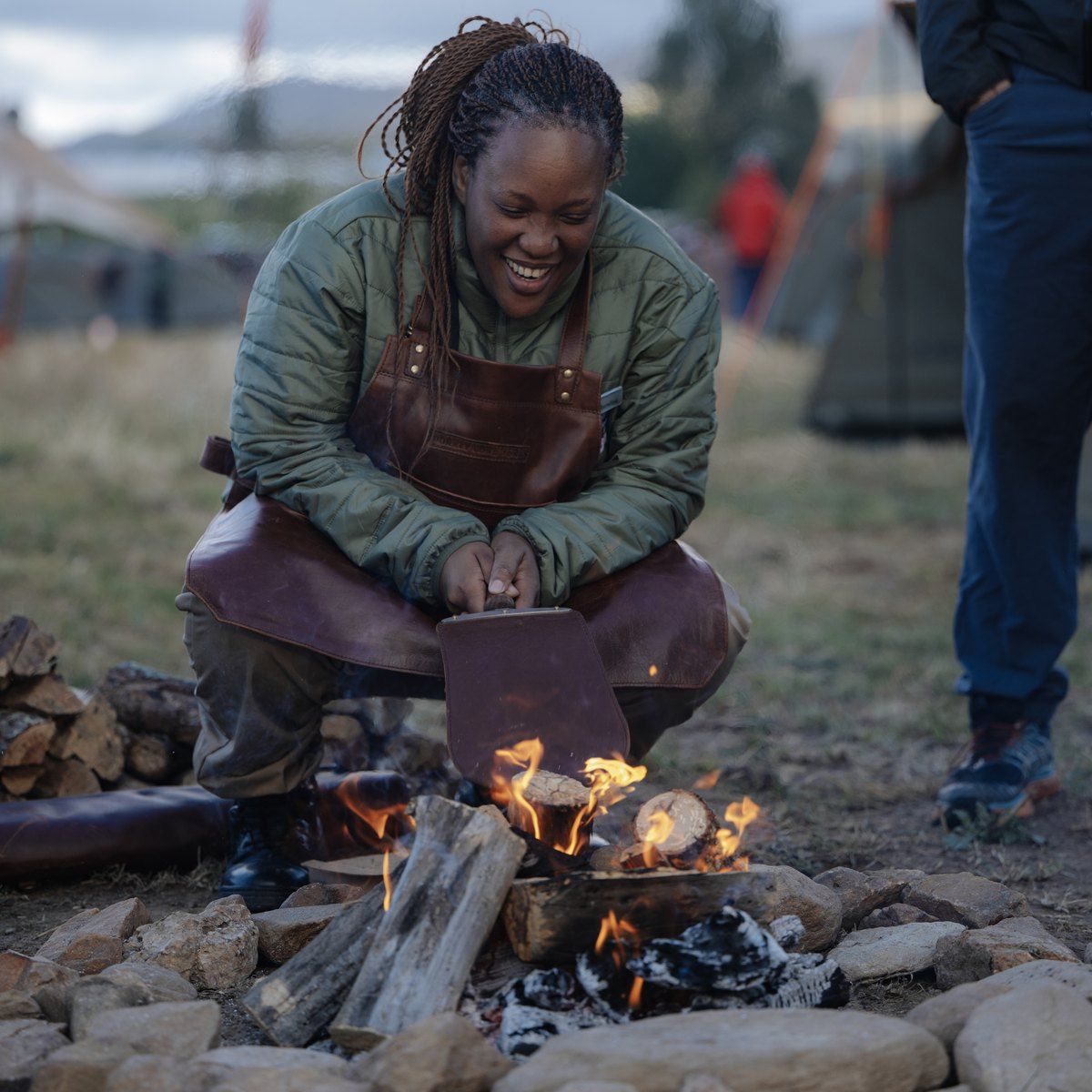 A Camp Master in a leather apron lighting the Lapa fire