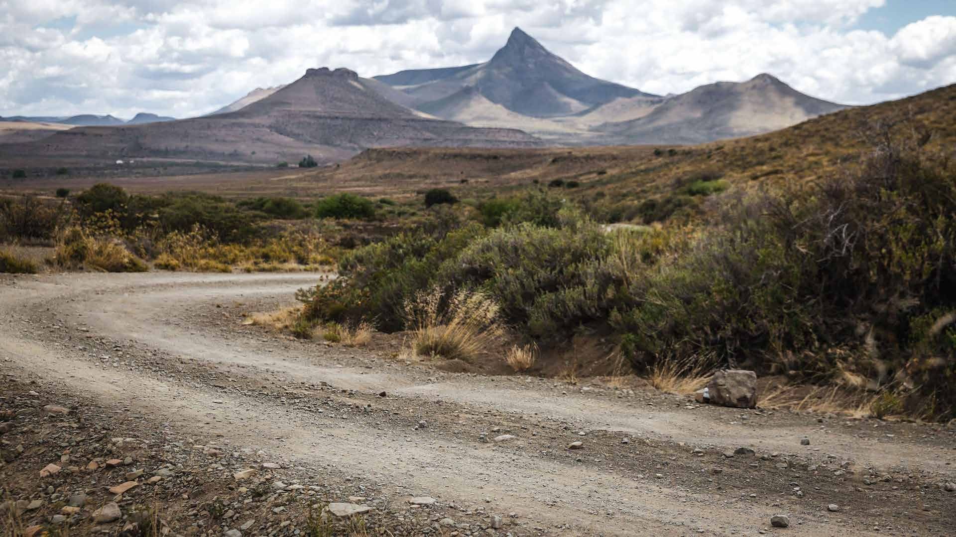 A gravel road winding towards Karoo mountains